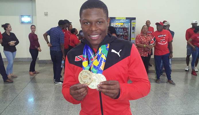 GOLD GALORE: TT cyclist Nicholas Paul shows off his three CAC Games gold medals on his return at the Piarco International Airport yesterday from Colombia.