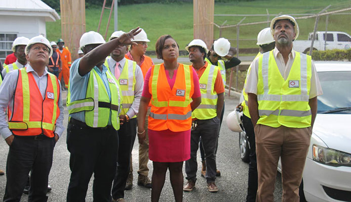 Project Manager Mc Jasse Salino points to the ongoing works at the Dwight Yorke Stadium, as Minister of Sport and Youth Affairs Shamfa Cudjoe (centre) and officials from THA, SPORTT and UDECOTT tour the facility on Tuesday.