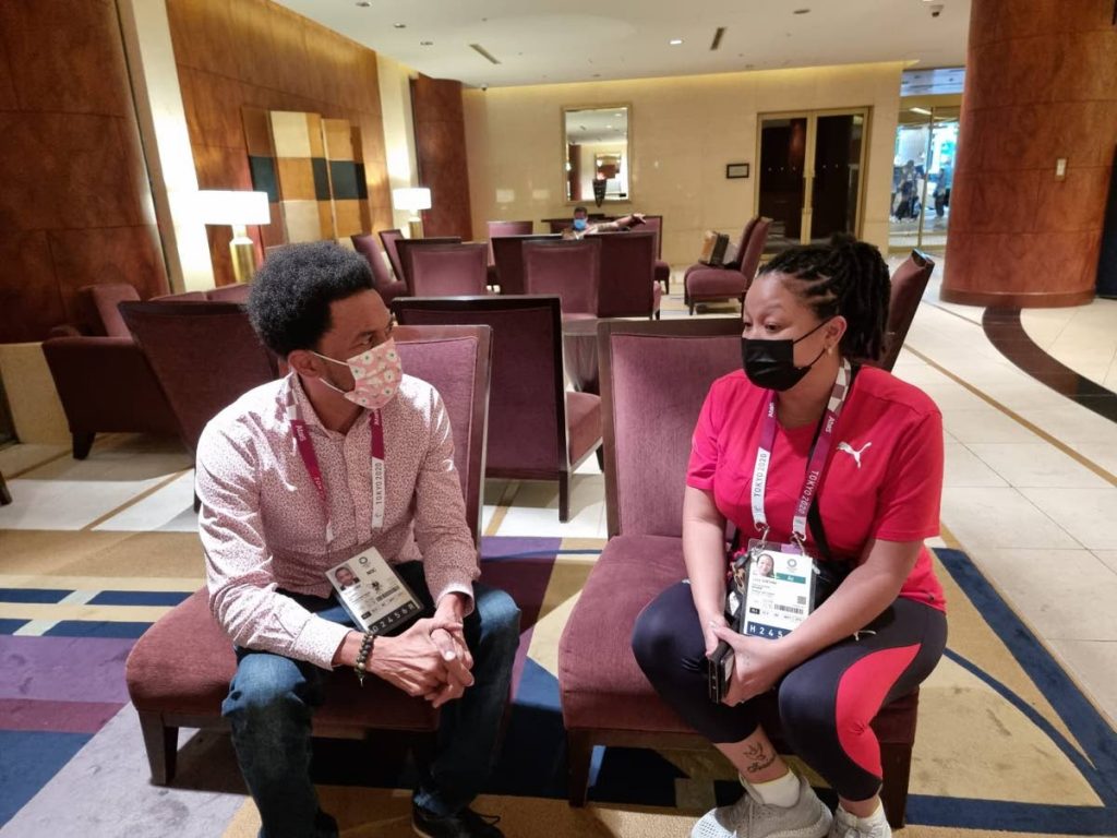 TTOC president Brian Lewis, left, has a discussion with chef de mission Lovie Santana during the Olympic Games in Tokyo, Japan. -