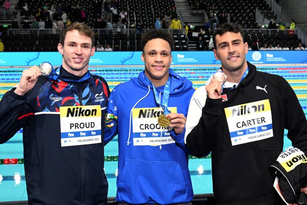 Jordan Crooks for the Cayman Islands (centre), Benjamin Proud from Britain (left), and Dylan Carter from Trinidad and Tobago display their medals from the men's 50m freestyle during the world swimming short course championships in Melbourne, Australia, on Saturday. Crooks won the gold, Proud earned silver and Carter took the bronze. (AP PHOTO) (TTOC obtained this photo via