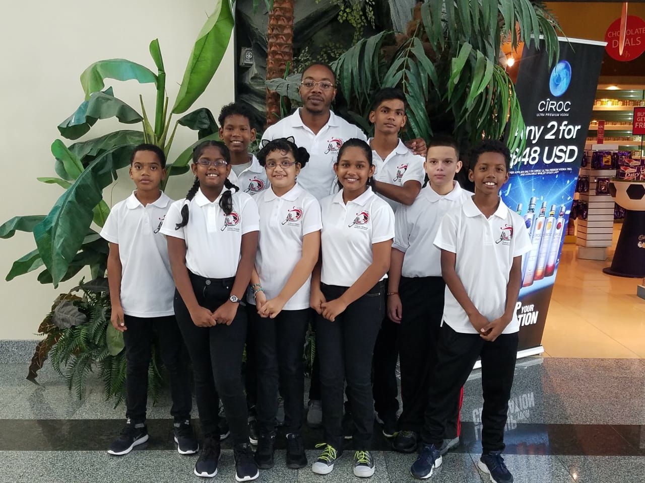 Coach Aaron Edwards, back-row centre, with members of the T&T Under-11 Boys’ and Girls; and Under-13 Boys’ teams prior to departure for the Caribbean Regional Table Tennis Federation Mini and Pre-Cadet Championship which serves today in Santo, Domingo.
